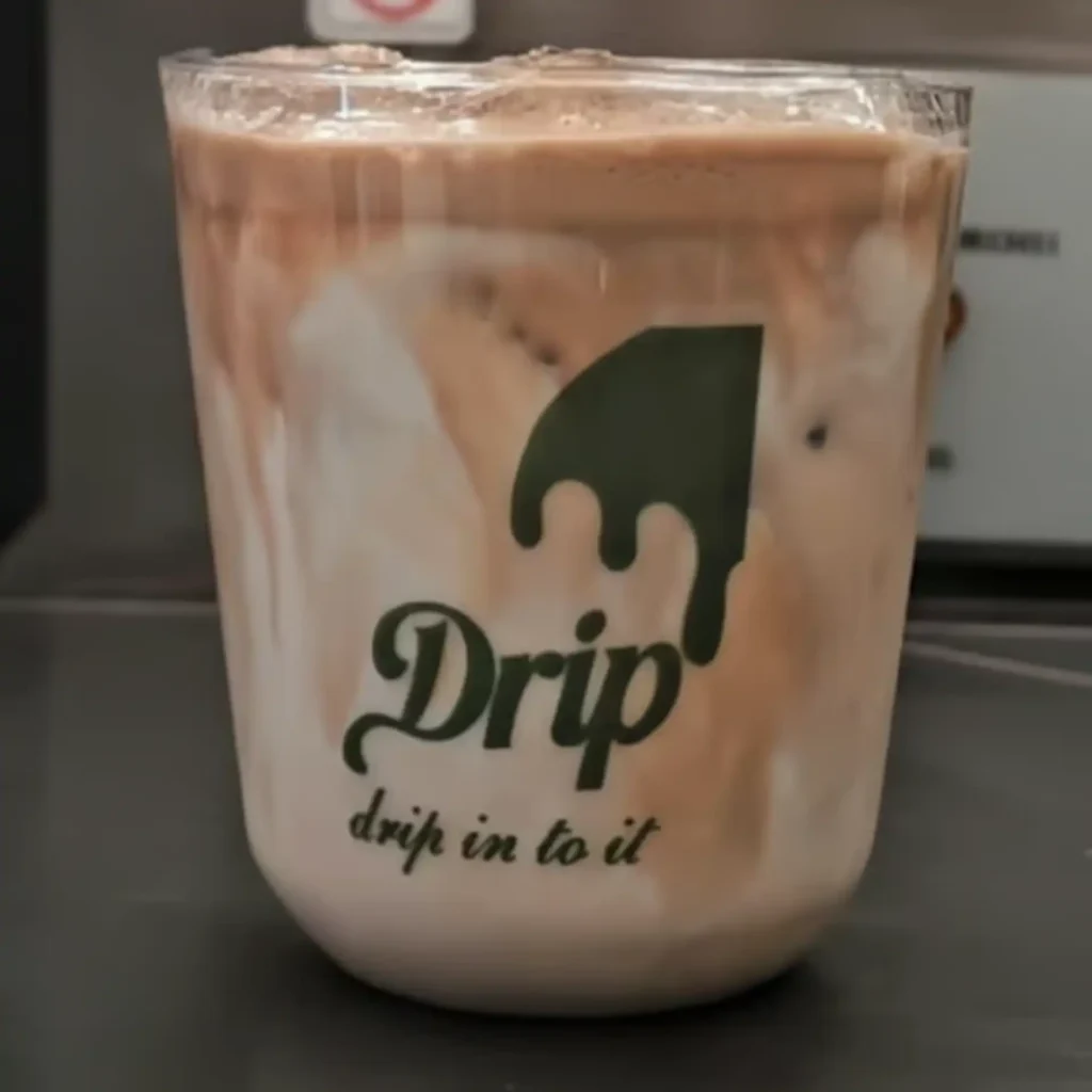 Drip Cafe Iced Latte, a creamy milk and espresso drink with distinct brown and white layers in a branded Drip cup.