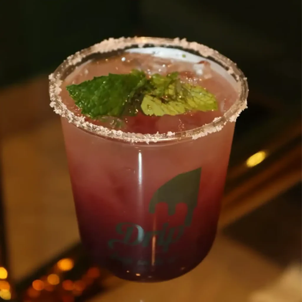 Drip Cafe Blackberry Blis Mojito, a deep red cold beverage with a frosty rim and a fresh mint garnish